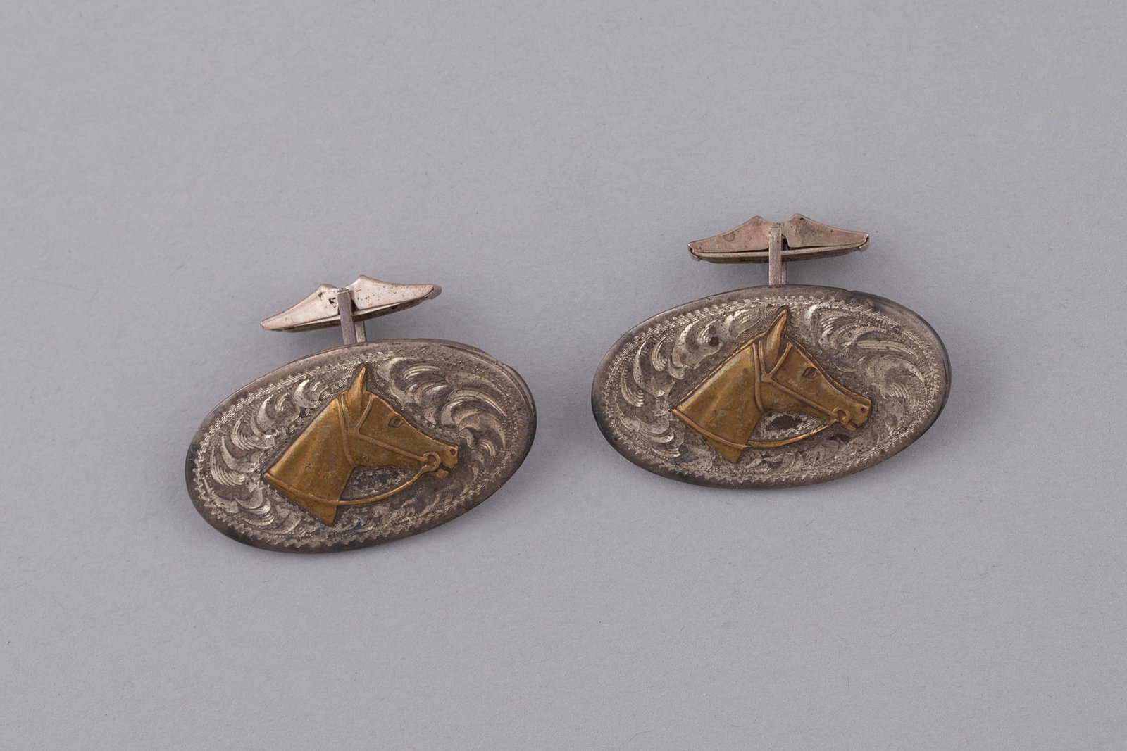 Pair of Vintage Rodeo Products Hand Engraved Sterling Silver & Brass Horse Cufflinks: These vintage Rodeo Products cufflinks are a classic example of mid-century Western silver artistry. Hand-engraved and featuring a striking two-tone design, they represent the authentic craftsmanship 