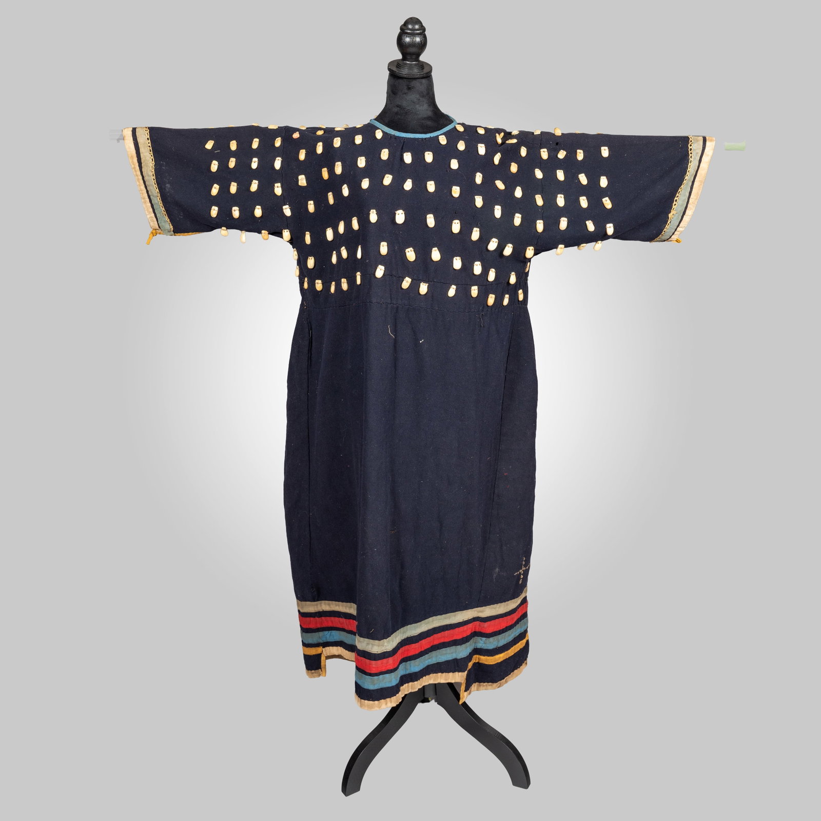 Apsáalooke (Crow) Style Wool and Ribbon Work Elk Tooth Dress: An elegant Northern Plains woman's dress. Constructed from heavy navy blue wool trade cloth in a traditional binary straight-line pattern. The upper bodice and sleeves are meticulously