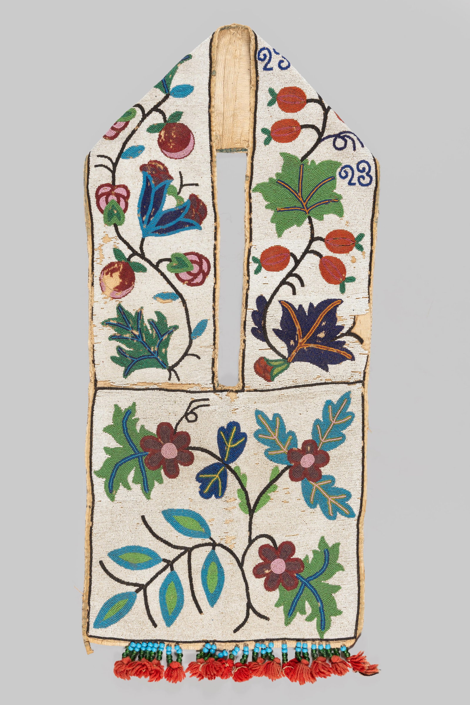 Great Lakes Beaded Bandolier Bag: Great Lakes beaded bandolier bag featuring extensive floral decoration executed in polychrome seed beads on a white ground. The wide shoulder strap is adorned with stylized leaves, berries, and