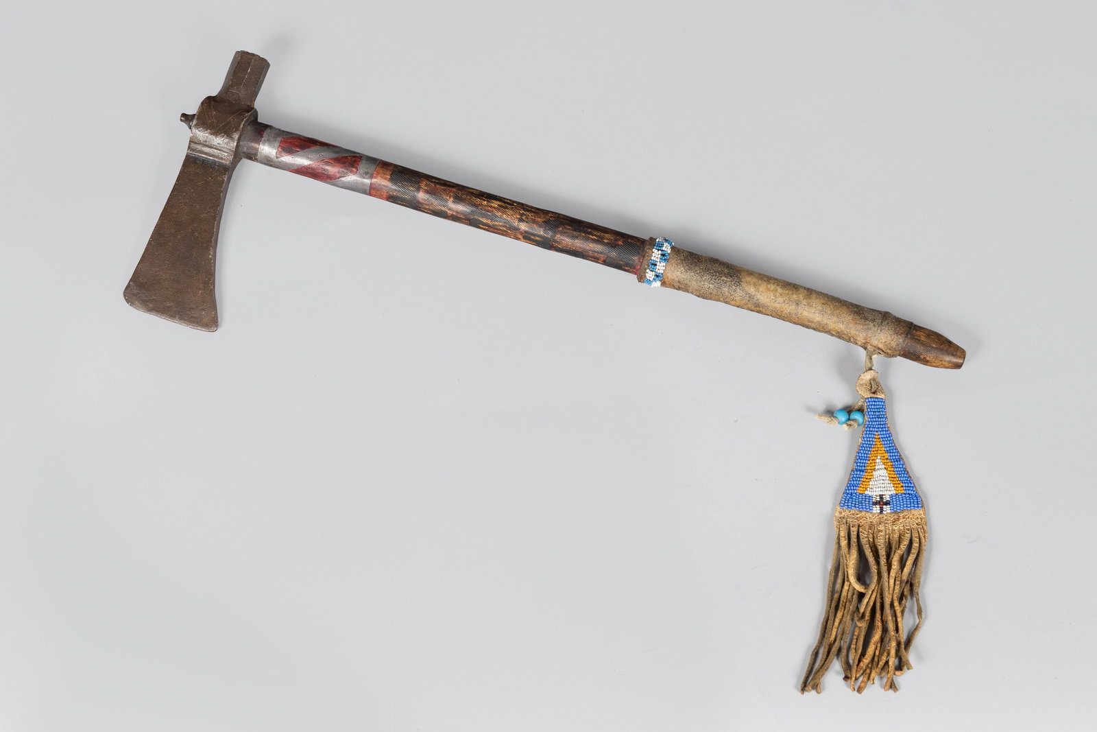 Early Pipe Tomahawk, Ca 19th Century: Early Pipe Tomahawk, Ca. 19th century. Blacksmith forged blade, octagon bowl, haft having pewter inlay, red ochre and file burns, wrapped with a hide handle and light blue, yellow, red, and navy