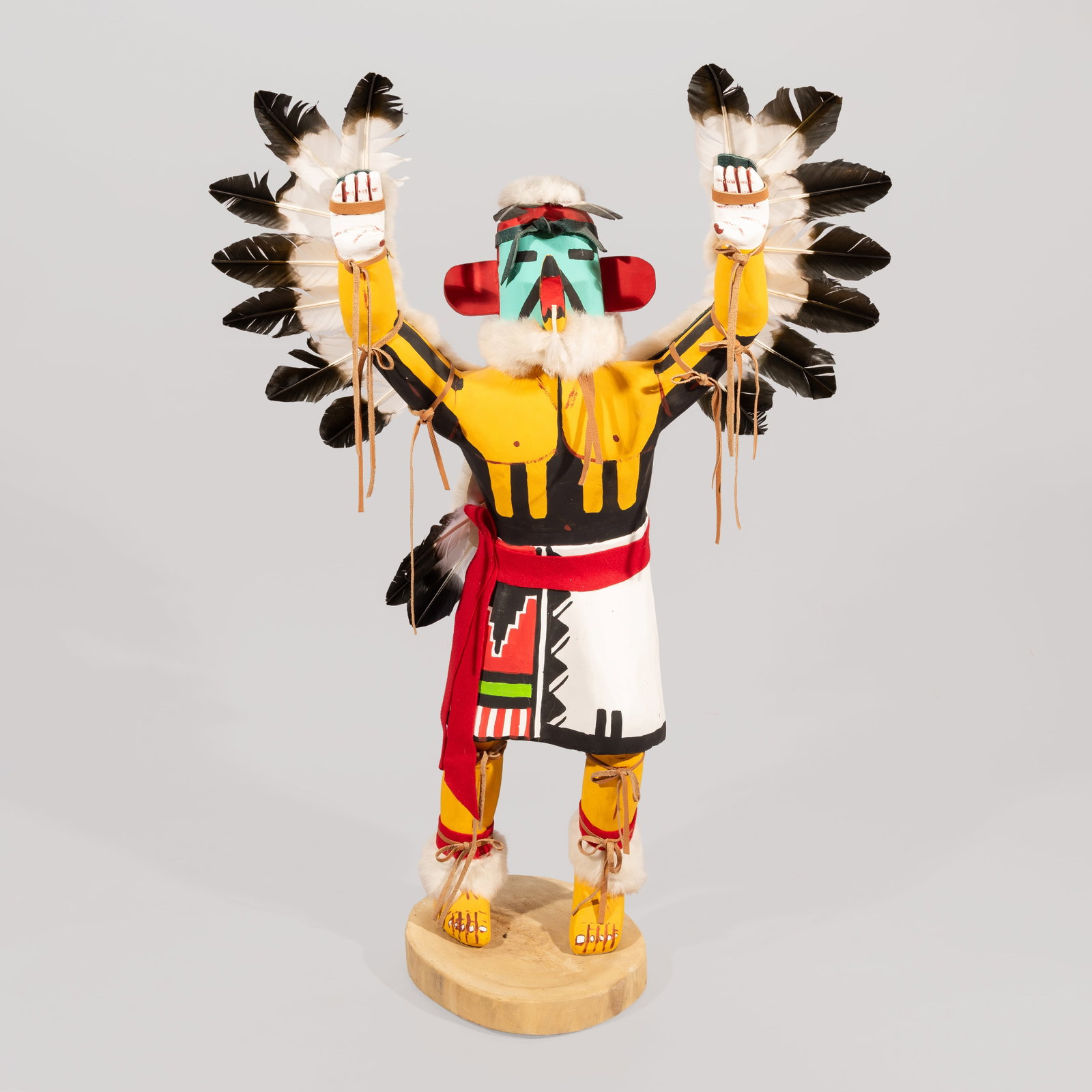 Large Hopi Eagle Dancer Kachina Doll: Carved and painted in vibrant polychrome pigments, this large-scale figure depicts a standing eagle dancer with outstretched arms, a turquoise mask with tab ears, feathered headdress elements, and art