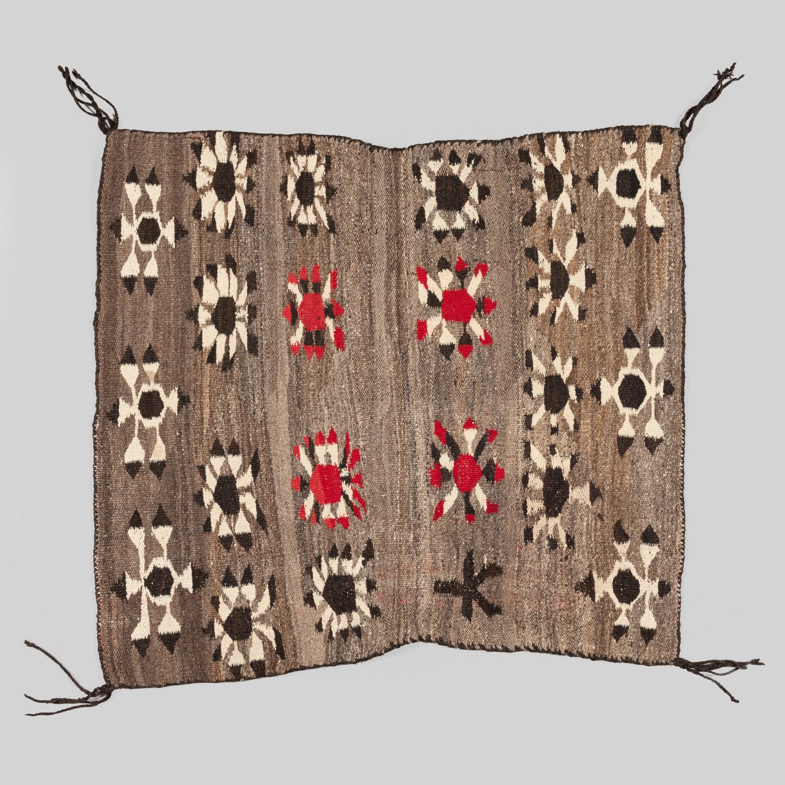 Bisti Pictorial: This finely hand-woven textile features the characteristic Bisti design aesthetic, showcasing a series of stylized, flower-like pictorial motifs across a variegated gray field. The piece utilizes a ri