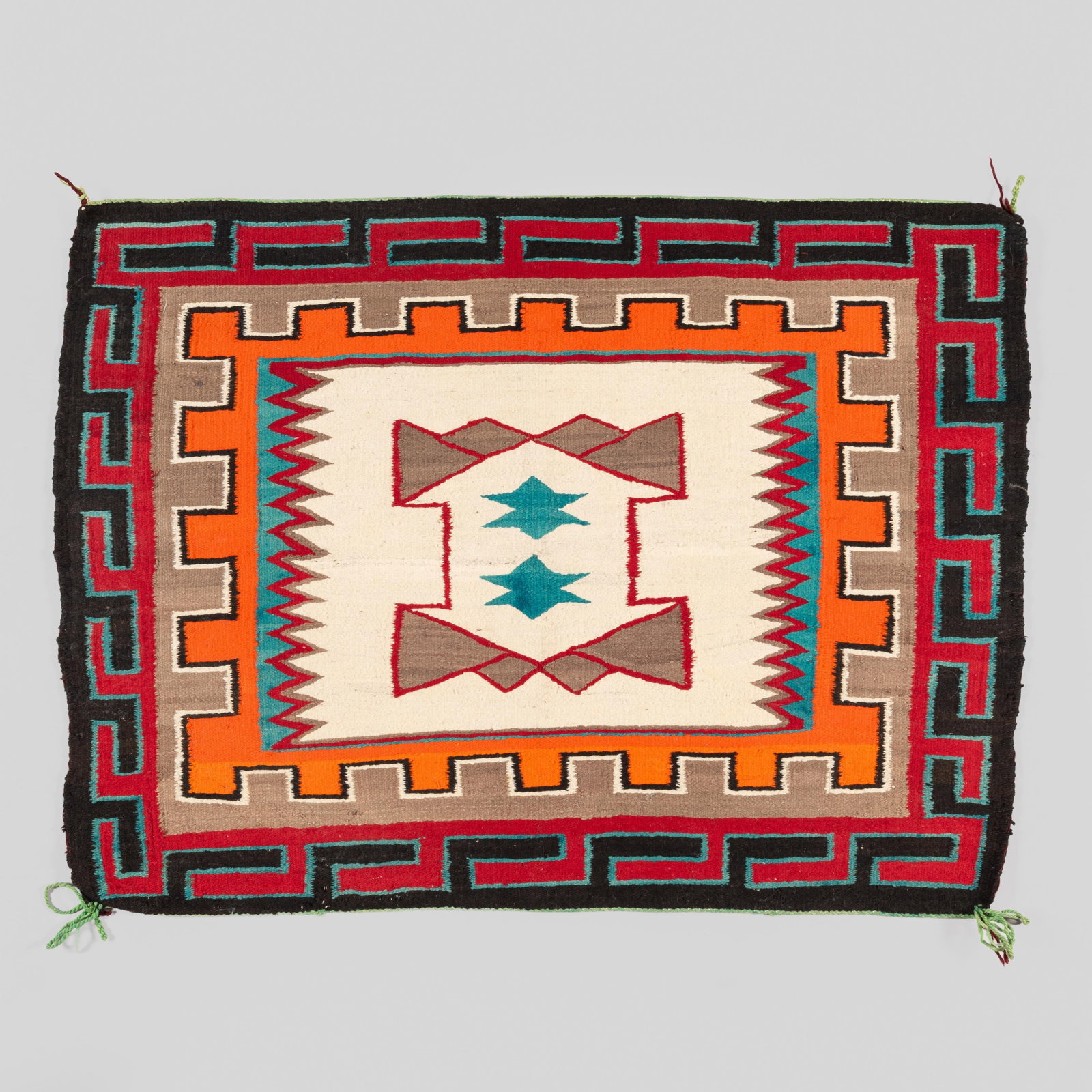 Navajo Red Mesa Regional Rug: An exceptional and striking Navajo Red Mesa Regional Rug, dating to the early 20th century. This handwoven wool flatweave features a bold, beautifully executed geometric composition. The central ivory