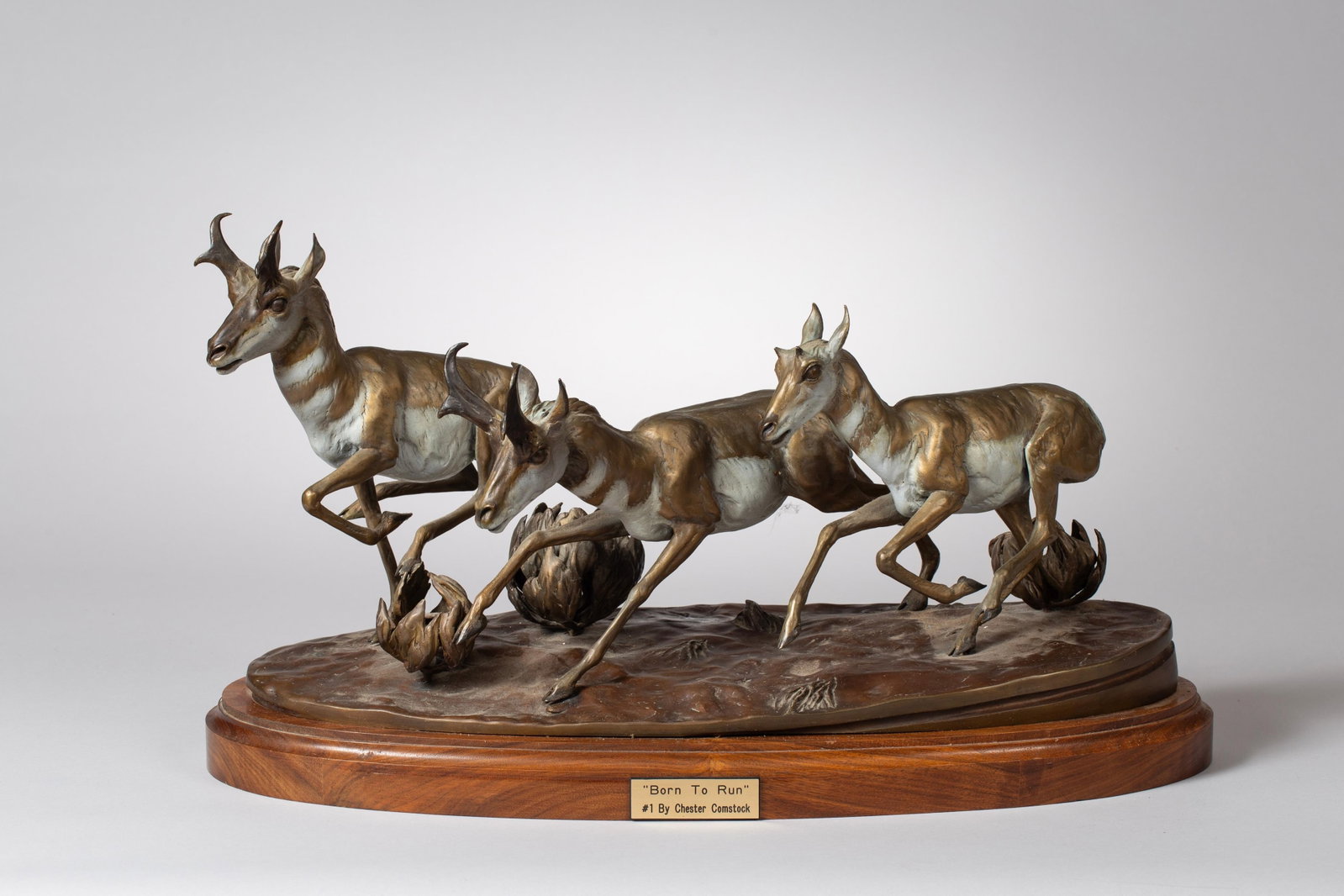 Chester Comstock "Born to Run" Bronze Statue, 1987: Sculpture of Running Antelope in bronze with metals chosen for color and workability, with delicate translucent patinas added. Delicate, translucent patinas have been applied to the surface, enhancing