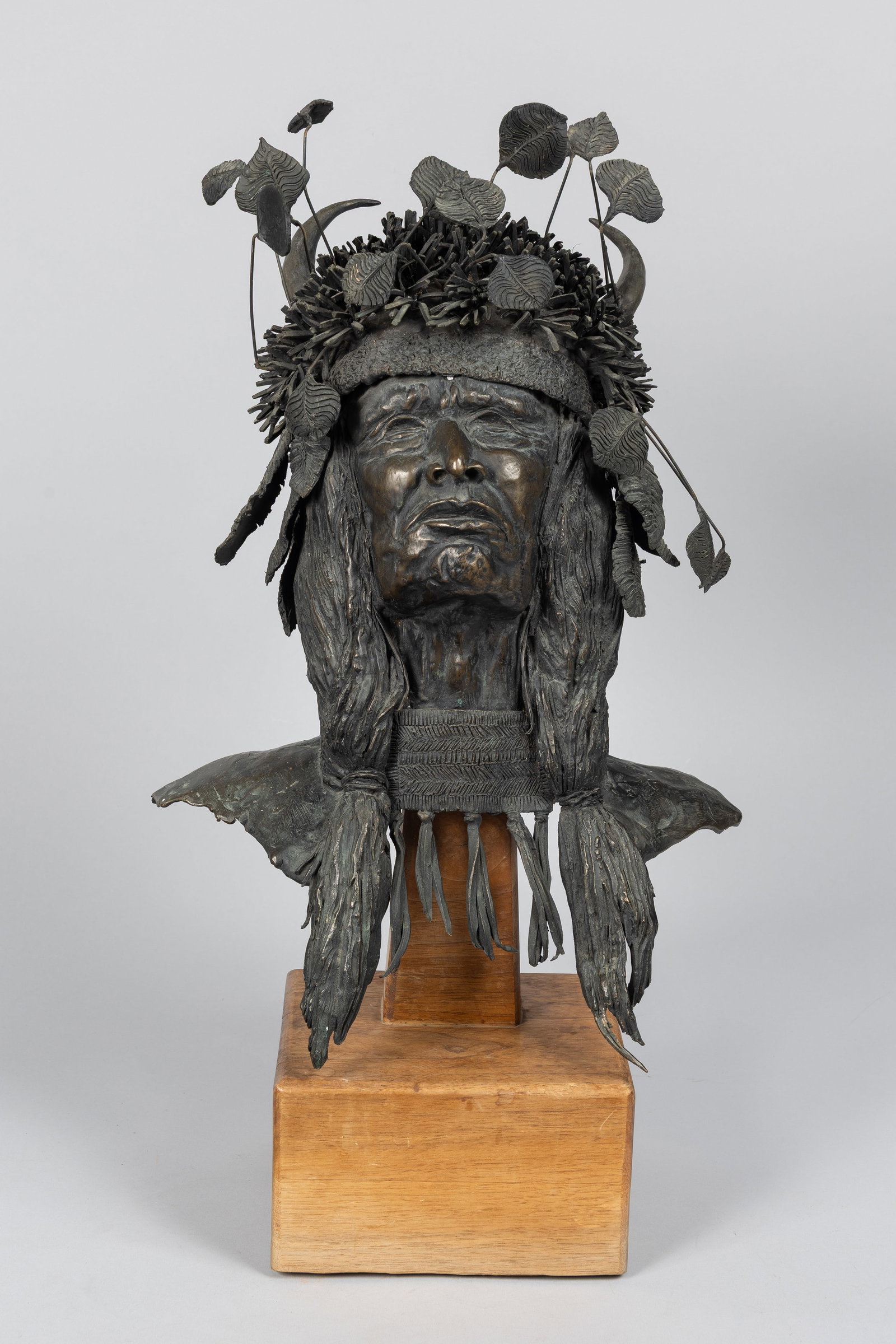 Carol Thornton (1926-2013), Bust of a Blackfoot Native American, Bronze Sculpture: Rare limited edition 6 of 10Signed and numbered by the artist on the back collarMounted on a wood baseA highly detailed, realistic portrait of a Blackfoot warrior adorned with a traditional split-horn