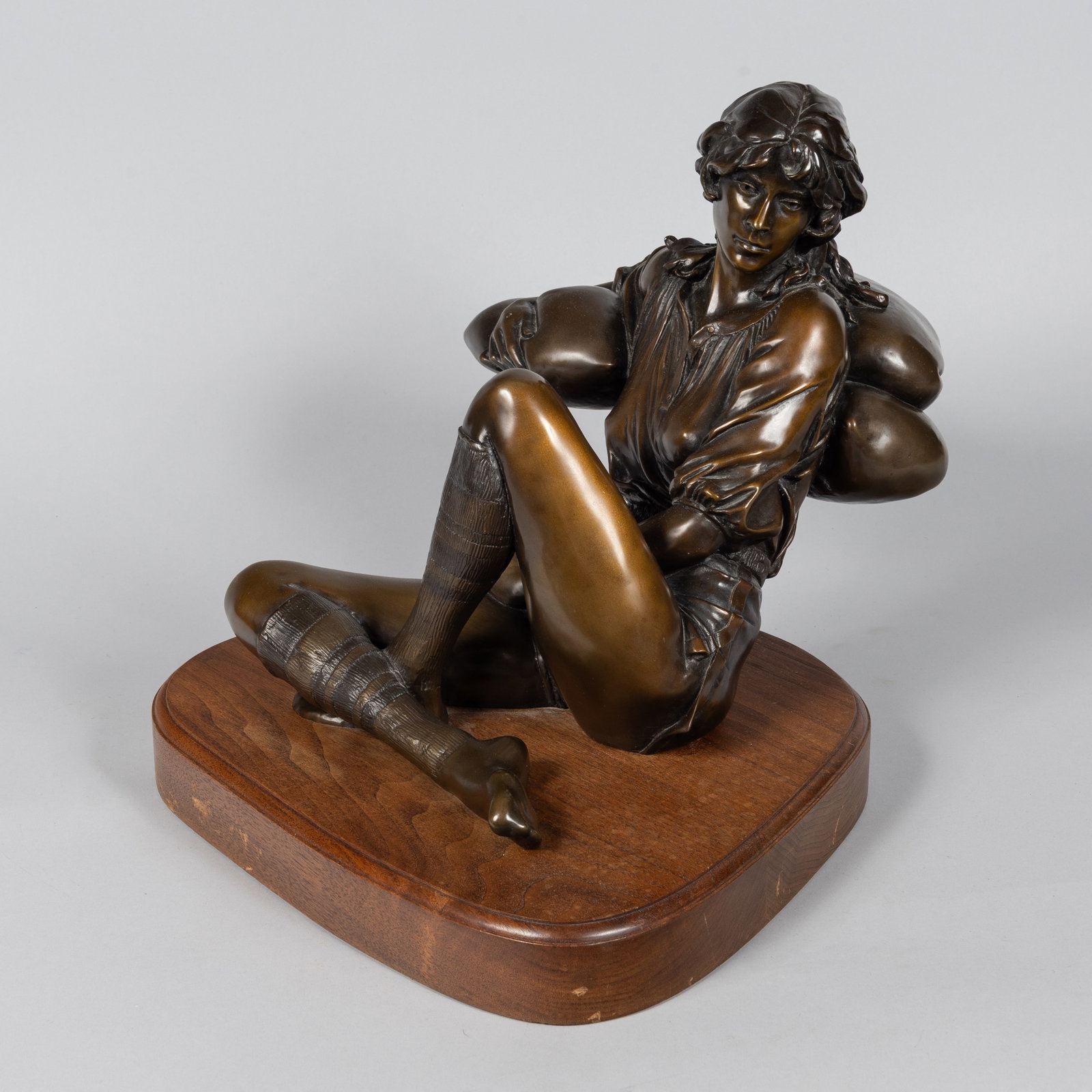 George Wayne Lundeen (b. 1948), Michelle, 1981: A beautifully cast, realistic patinated bronze figurative sculpture titled "Michelle" by renowned American sculptor George Wayne Lundeen. The artwork captures a young woman in a reflective, seated pos