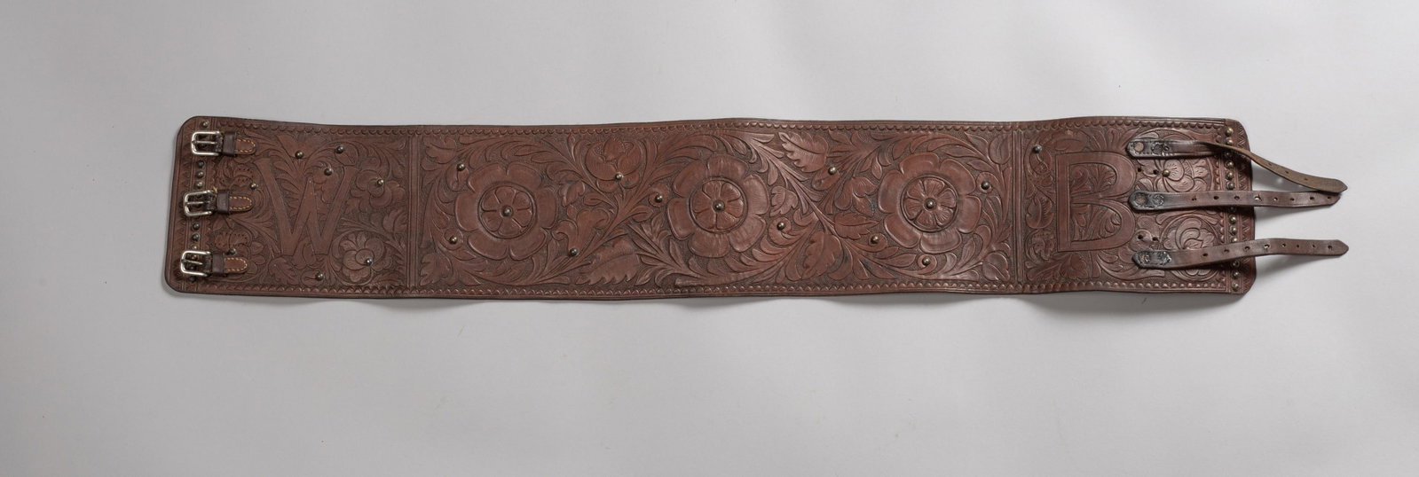 Finely Floral Tooled Bronc Belt: A beautifully crafted, vintage Western Bronc Belt. This wide, heavy-duty leather belt features exquisite, deep floral tooling across the entire main body and brass studs showcasing exceptional