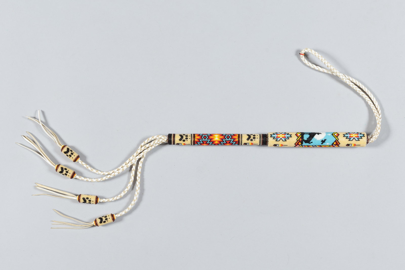 Deer Lodge Prison Beaded Native American Quirt: Handcrafted by inmates at the Montana State Prison in Deer Lodge. These collectible pieces of Western folk art feature a stiff braided handle and a leather strap. They are highly prized for their