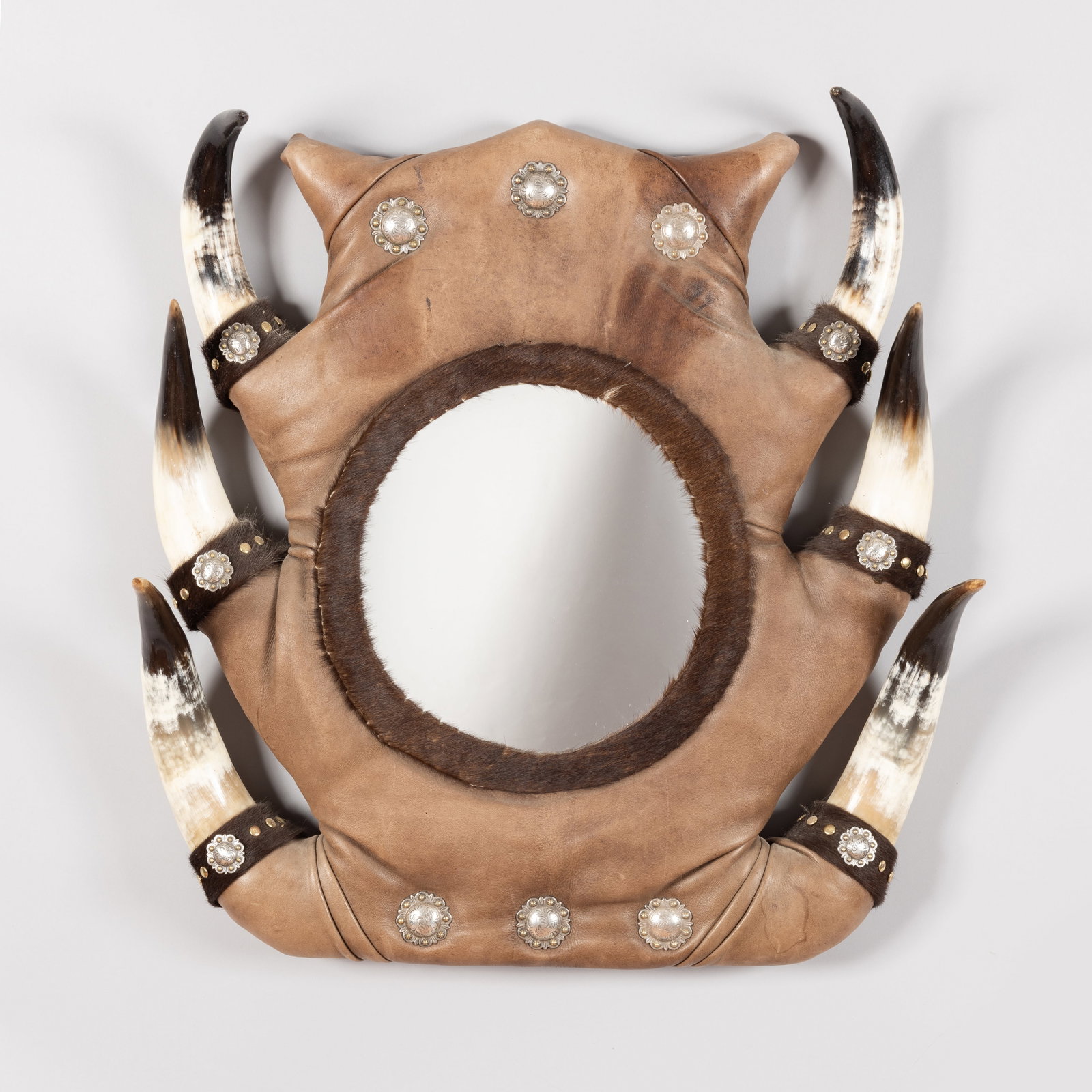 Vintage style Horn Mirror: A magnificent vintage wall mirror that captures the spirit of the Wild West. The circular mirror is set within a robust, hand-crafted leather frame featuring a distinctive scalloped edge. This impress