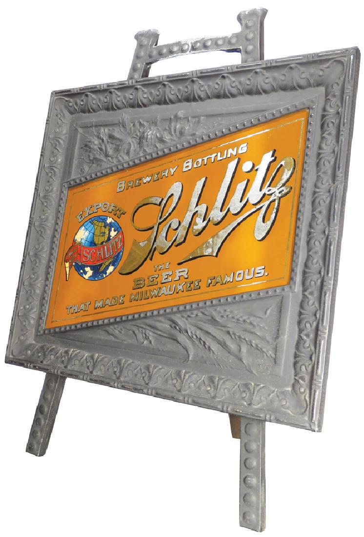 Schlitz Brewing Company Reverse Glass Sign: Schlitz Brewery Bottling Company Reverse Glass Sign in original embossed tin frame and easel holder. Some paint lifting otherwise very good condition. Frame measures 22 3/4 X 20 3/4 inches.
