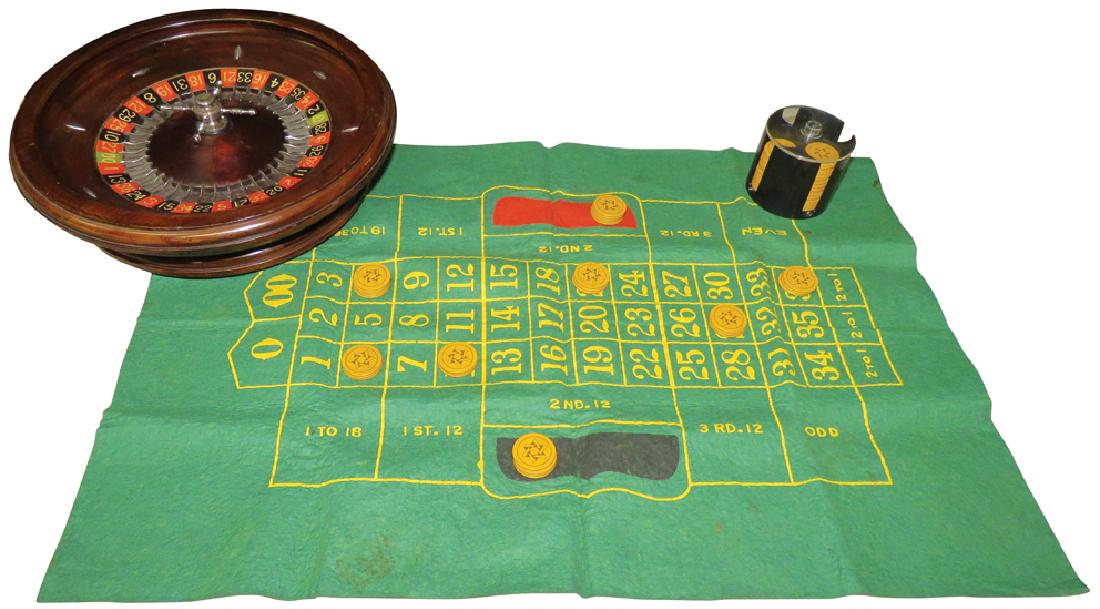 Portable Roulette Wheel and Layout: Portable Roulette Wheel and Layout. Footed wheel and felt layout. Comes with bakelite poker chips and caddy. Wheel measures 16 inch diameter.