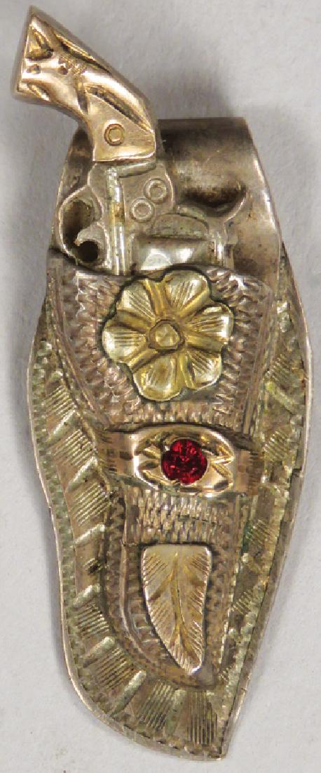 Vintage Sterling Silver & 10k Gold Western Pendant: Vintage Sterling Silver & 10k Gold Gun and Holster Pendant with ruby stud. Etched detail, gun comes out of holster. Stamped on back. 1/2 X 1 1/2 inches.