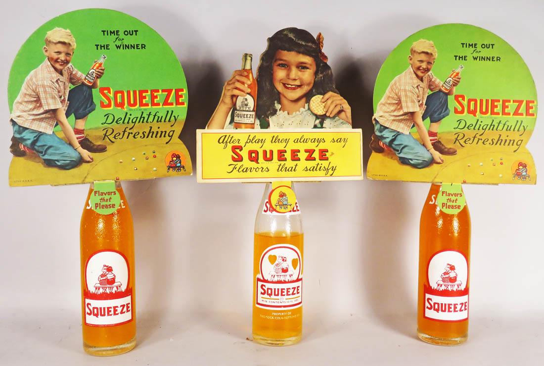 Three Orange Squeeze Soda Bottles and Toppers: Three Orange Squeeze Soda Bottles and Die Cut Cardboard Toppers. Very good condition. Aprox. 7 1/2 X 10 inches each overall.