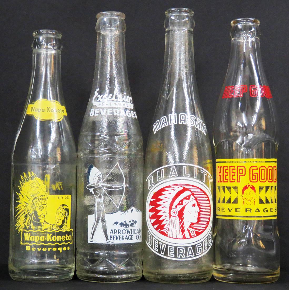 Four Native American Motif Soda Bottles: Four Native American Motif Soda Bottles. Embossed bottles with enamel labels including Heep Good, Mahaska, Excelsior-Arrowhead Beverage Co (crack at top lip) and Wapa-Koneta. 8 to 10 fluid ounces.