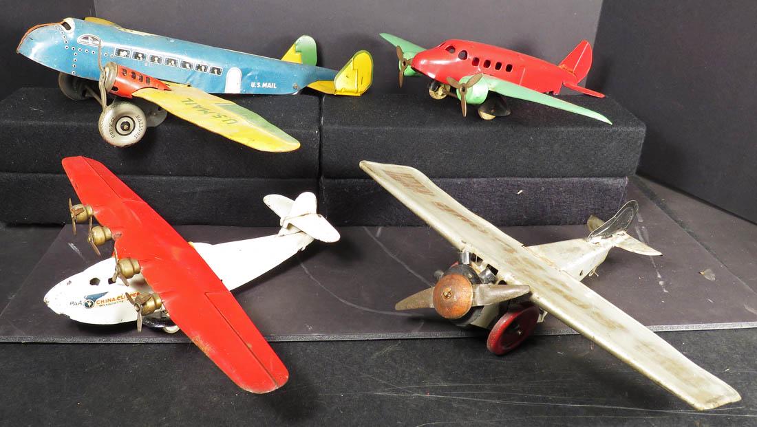Collection of Four Tin and Pressed Steel Toy Airplanes: Collection of Four Vintage Tin and Pressed Steel Toy Airplanes. Spirit of St Louis tin with repair on wing. Louis Marx U.S. Mail TWA tin litho. Wyandotte Toys "China Clipper" and Red/Green pressed ste