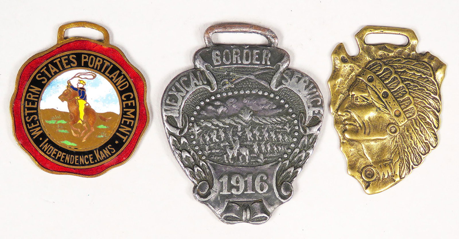 Collection of Three Vintage Watch Fobs: Collection of Three Vintage Watch Fobs. 1916 Mexican Border Service. Native American Profile on arrow head, brass. Advertising Western States Portland Cement, Independence, KS, enamel.