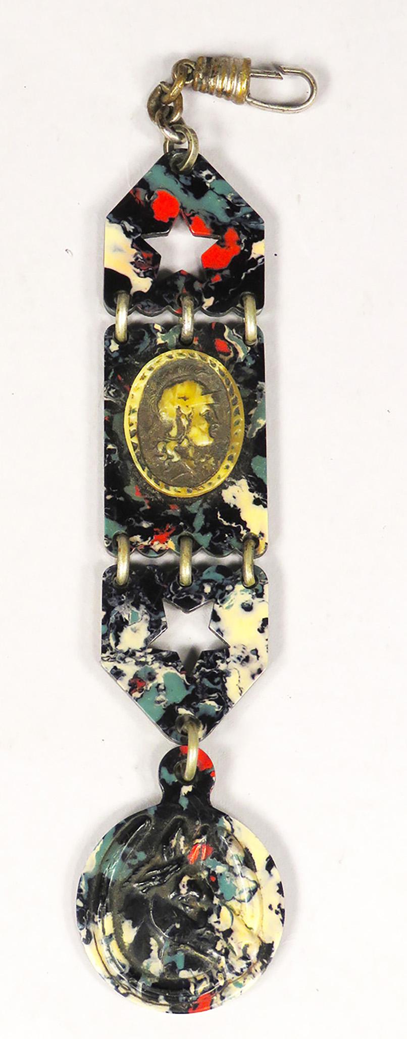 Antique "End of Day" Bakelite Watch Fob: Antique "End of Day" Bakelite Watch Fob. Beautifully marbled end of day Bakelite. Embossed horse at bottom and applied Spartan warrior cameo in center with cut out stars. Very unique. 5 inches long.