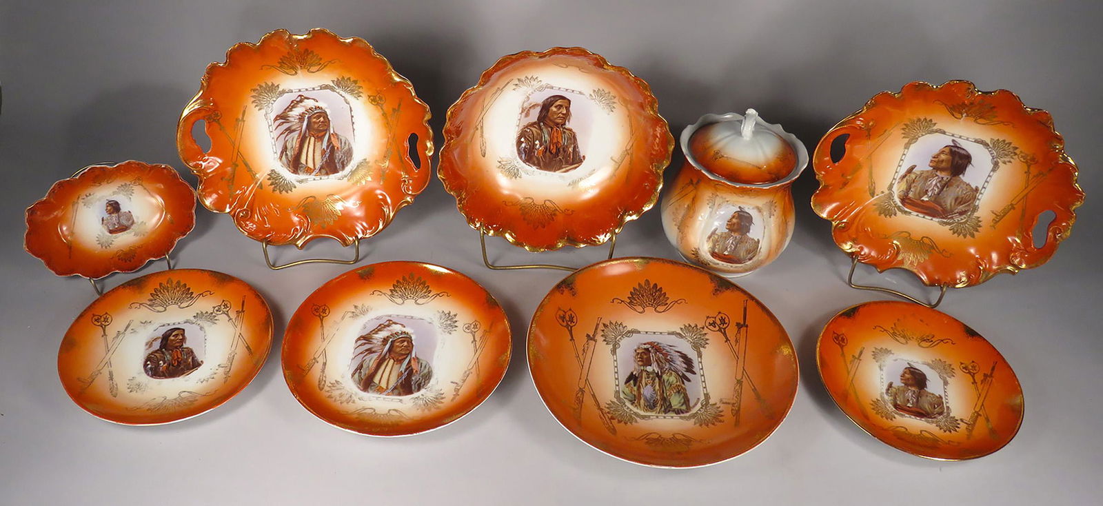 Collection of Royal Saxe German Porcelain: Collection of Royal Saxe German Porcelain. Burnt orange border with Native American Motif. Large bowl, biscuit jar, small tray and (6) various size plates. Images include Left Hand Bear, Sitting Bull,