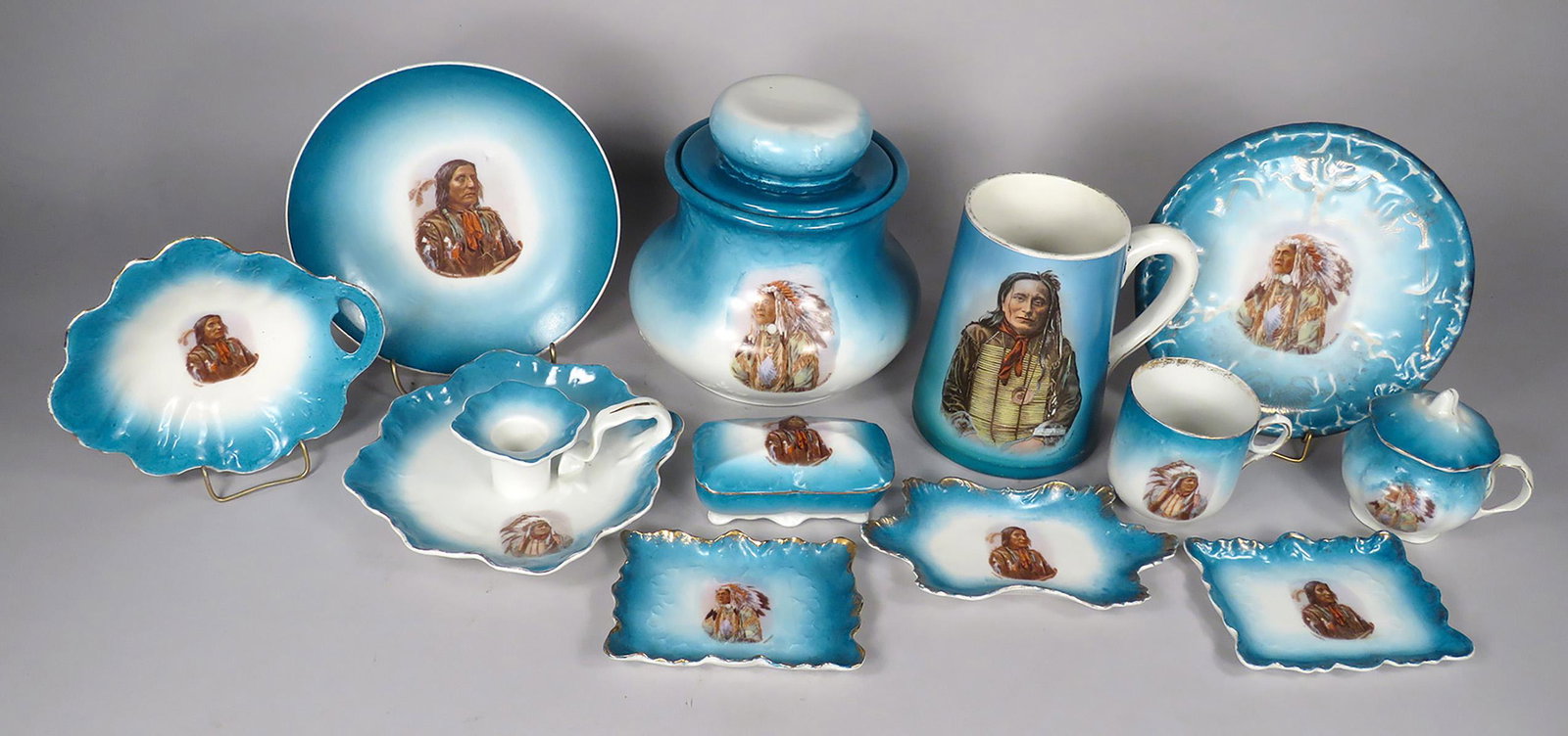 Collection of Teal Royal Saxe German Porcelain: Collection of Teal Royal Saxe German Porcelain. Teal trim with Native American Motif. Humidor, candle holder, (4) trays, small embossed plate, trinket box, jam jar and handled cup. Large mug with imag