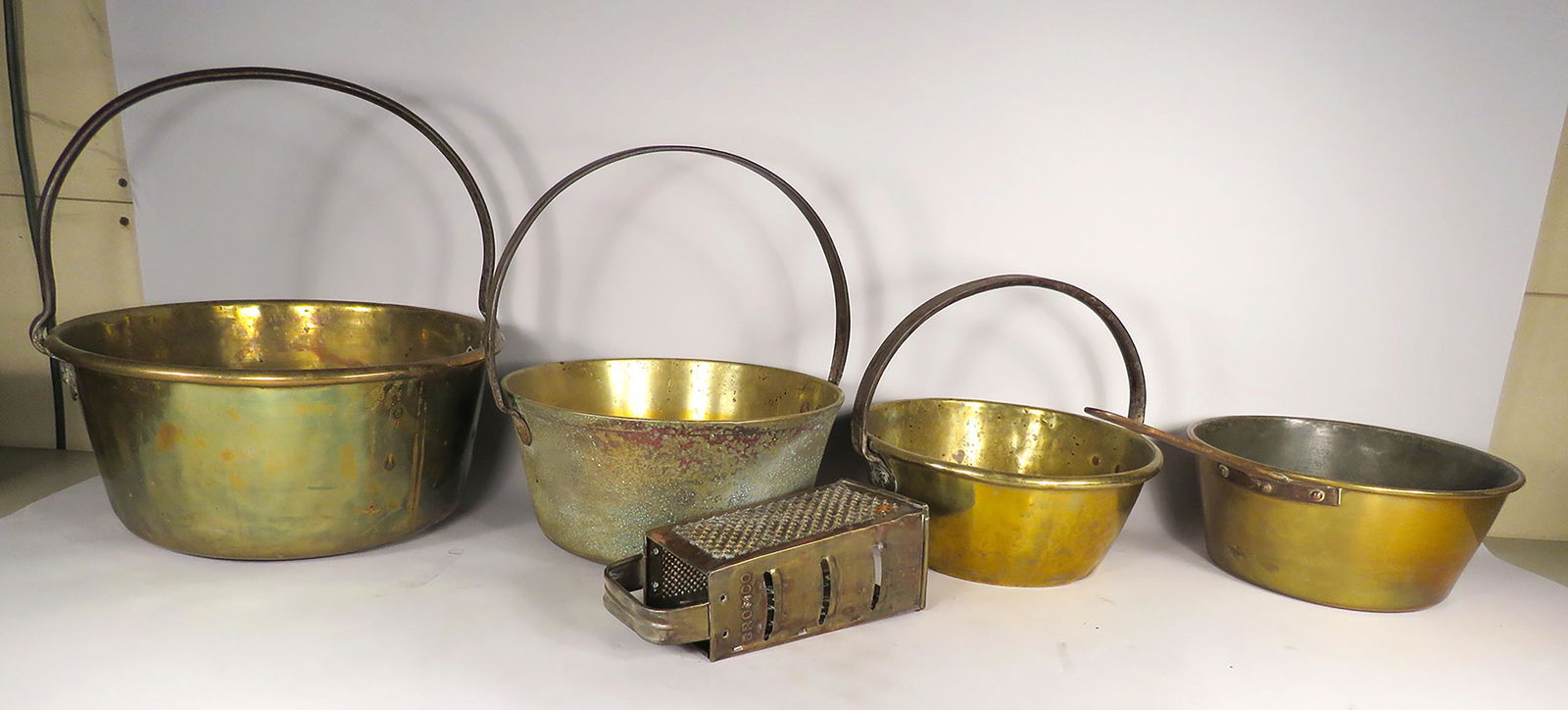 Collection of Antique Brass Cookware: Collection of Antique Brass Cookware. 3 pots with handles 11-13 inch diameter, 10 1/2 inch pan with handle and cheese grater.