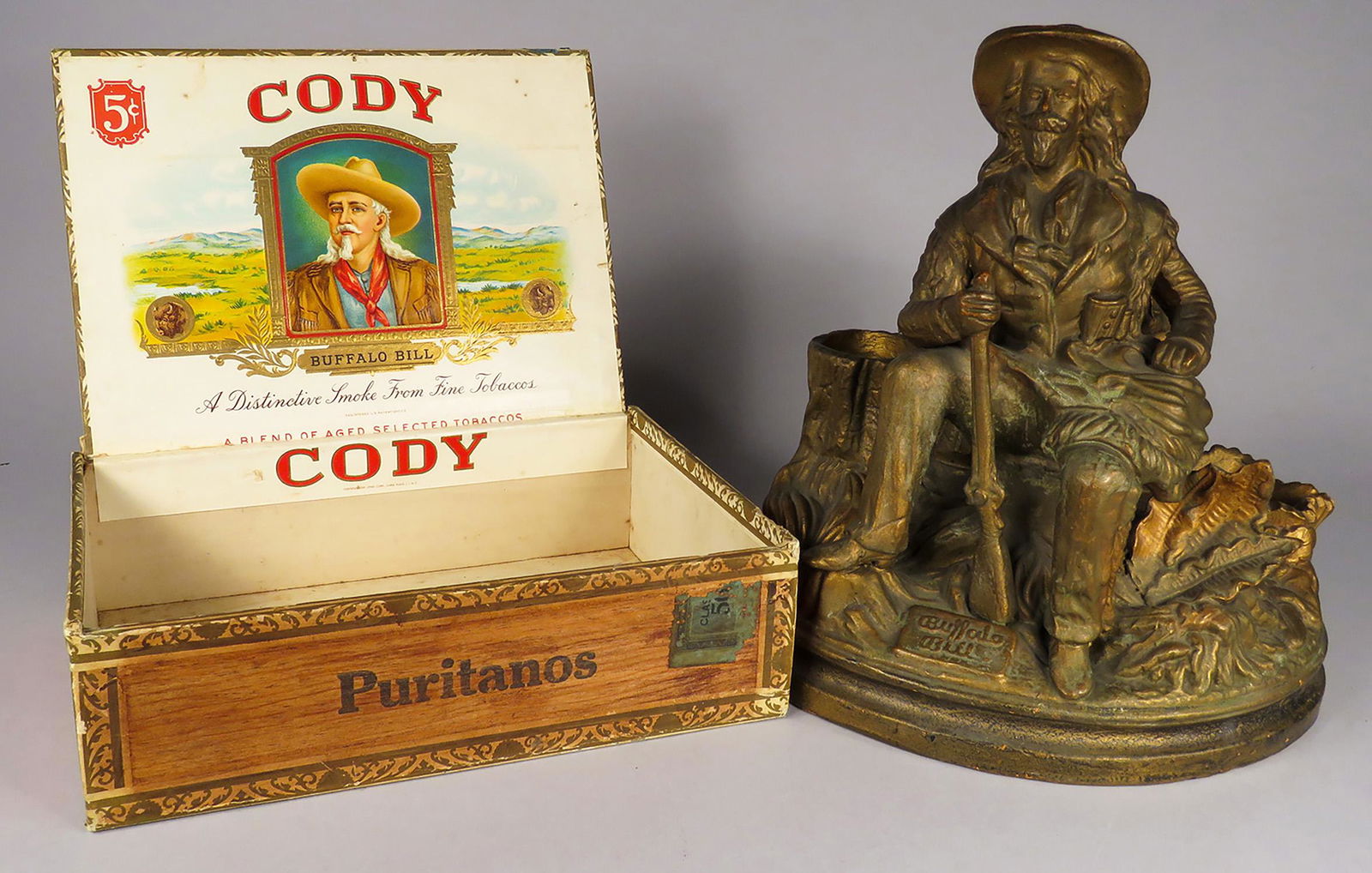 Buffalo Bill Motif Smoking Station and Cigar Box: Buffalo Bill Motif Smoking Station and Cigar Box. Great gold wash patina 8 1/2 inch diameter X 9 1/2 inches tall. Cigar box with original interior label.