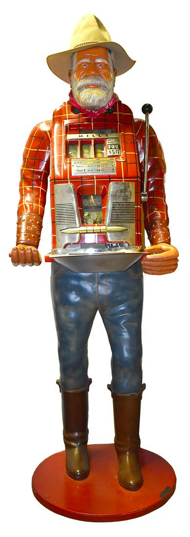 Mills 25 Cent One Armed Bandit Slot Machine: Mills, 25 Cent, Coin Operated, One Armed Bandit, "Miner" Slot Machine. Carved mid century. 78 inches overall w/hat.