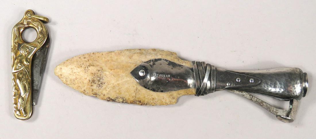 Two Antique Cigar Tip Cutters: Two Antique Cigar Tip Cutters. Sterling silver and original arrowhead, 5 1/4 inches long. Pocket cutter is brass with embossed nude motif, 2 1/2 inches long.