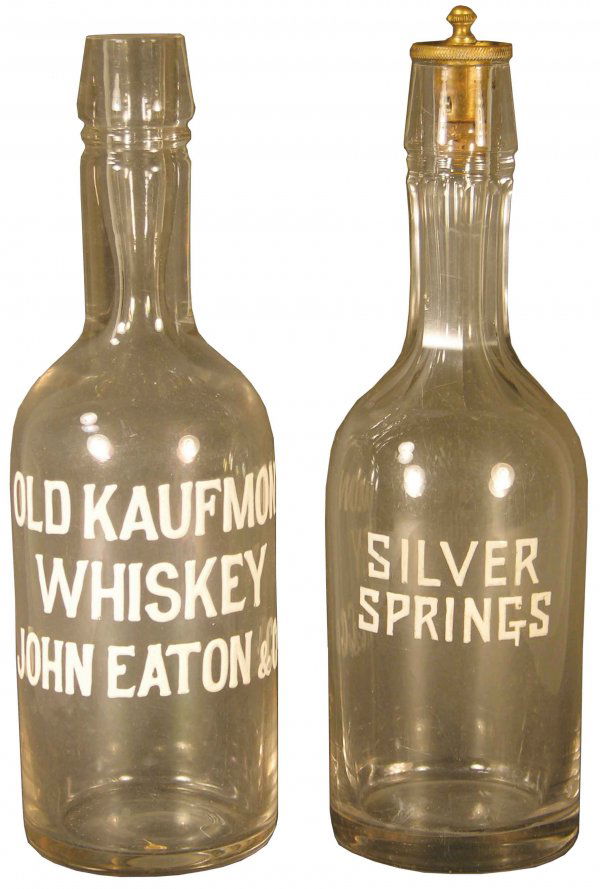 Lot of Two Enameled Label Liquor Bottles: Two Enameled Label Liquor Bottles. One Old Kaufman Whiskey the other Silver Springs. Aprox. 11 inches tall.