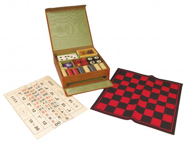 Leather Gamblers Box, 1906 Complete: Leather Gamblers Box, 1906. Comes with domino cards, playing cards, dice, set of chess/checker pucks, two markers, chips, roulette layout and felt game board. Excellent condition. Measures 8 X 8 1/4 X