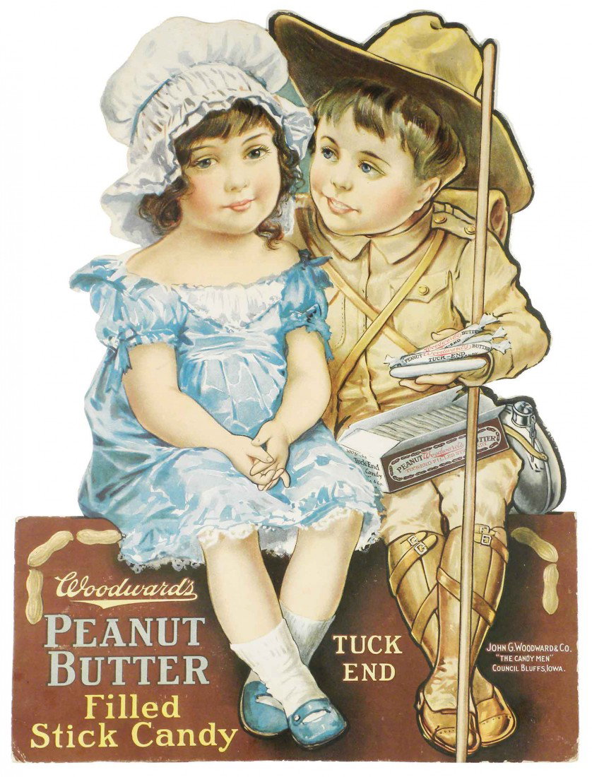 Woodward's Peanut Butter Stick Candy Sign: Woodward's Peanut Butter Filled Stick Candy Die Cut Cardboard Sign. Depicting a little boy and little girl. John G. Woodward & Co. Council Bluffs, IA. Framed under glass. Excellent condition. 10 X 14 