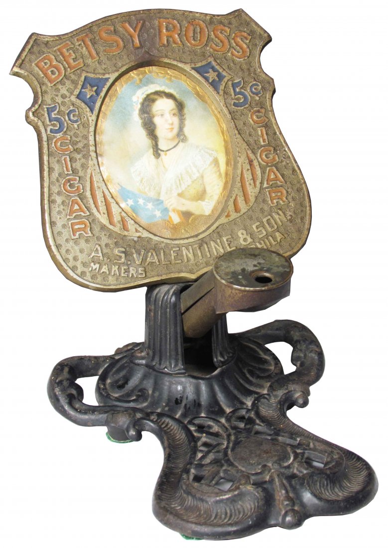 Betsy Ross Cigars Cast Iron Cigar Tip Cutter: Betsy Ross Cigars Cast Iron Cigar Tip Cutter. A. S. Valentine and Son Makers, Phila. Made by the Brunhoff Mfg. Co. Age discoloration on frame otherwise overall good condition. 6 X 7 3/4 X 8 inches.