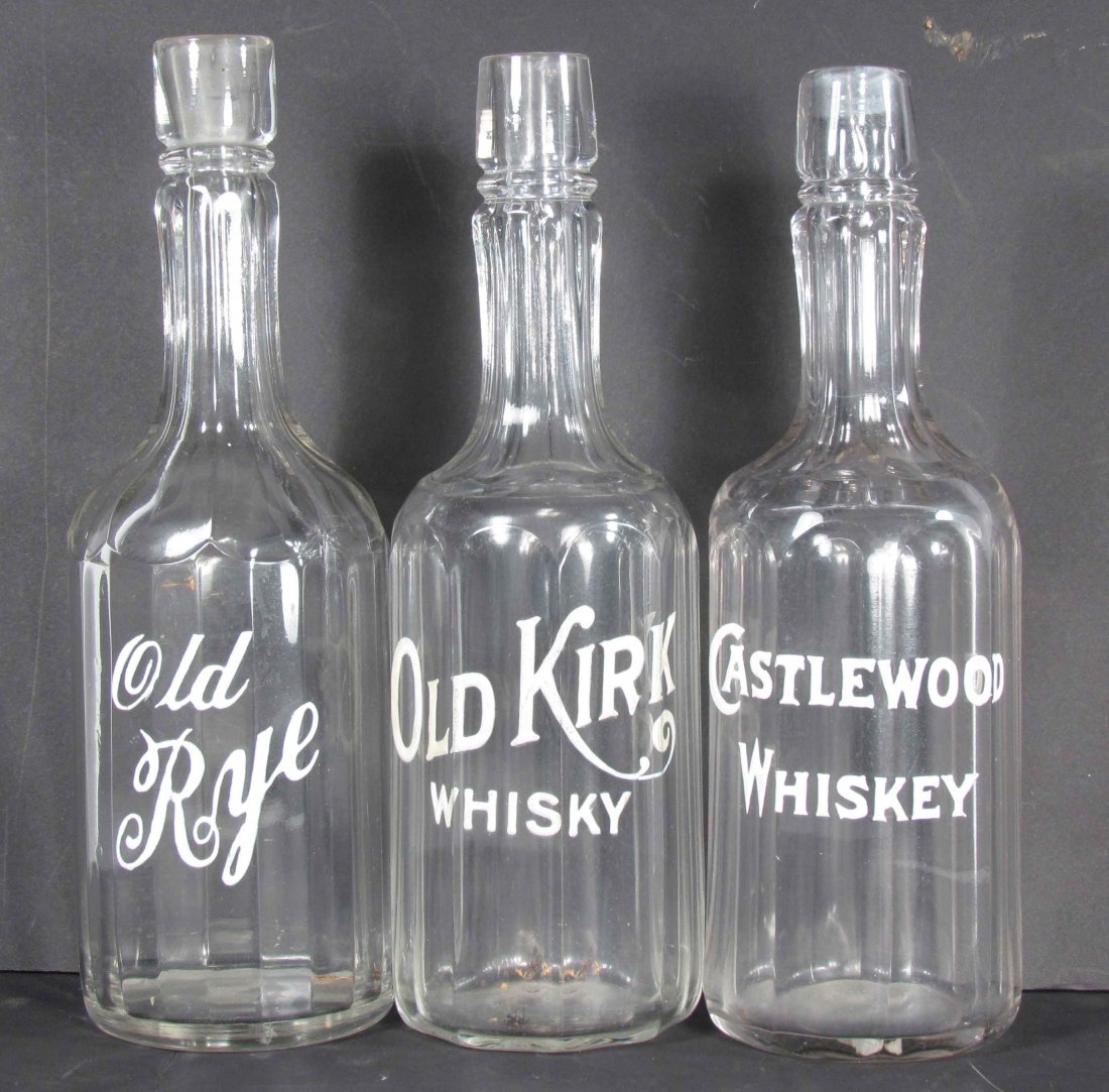 Three Enameled Back Bar Bottles: Three Enameled Label Back Bar Bottles. Castlewood Whiskey, Old Kirk Whisky, and Old Rye. No chips or cracks. Approximately 11 inches tall.