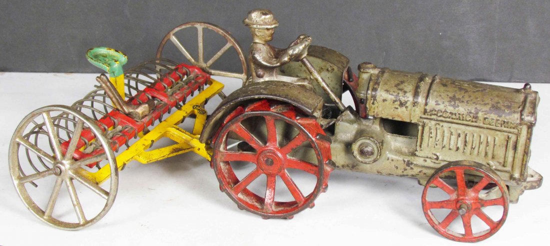 Arcade Toy Co. Cast Iron McCormick Tractor: Arcade Toy Co. Cast Iron McCormick Tractor with dump rake implement. Most of original paint gone otherwise good condition. 10 inches long overall.