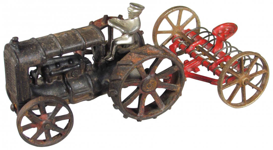 Arcade Toy Co. Cast Iron Tractor and Rake: Arcade Toy Co. Cast Iron Tractor and dump rake implement. Most of original paint intact otherwise good condition. 9 inches long.