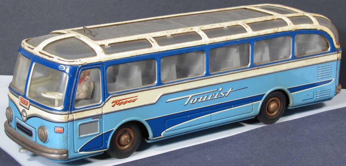 Tippco "Tourist" Tin Litho Toy Bus: Tippco "Tourist" Tin Litho Toy Bus. Made in Western Germany, friction propelled. Roof slides to reveal an open air ride. Minor paint loss and discoloration otherwise good condition. 13 1/4 inches long