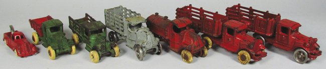 Seven Cast Iron Toys: Seven Cast Iron Toys. (2) 2-pc Red Cattle Trucks. Red Gasoline Truck. Arcade red wrecker. Red and green dump truck. Green stake truck. Grey stake truck. Overall fair to good condition. Cattle hauler m