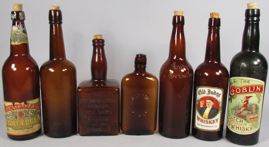 Collection of 7 Antique Amber Glass Bottles: Collection of 7 Antique Amber Glass Bottles. Old Gilt Edge Whiskey (embossed), Mount Vernon Pure Rye (embossed), Rustaller's Gilt Edge Lager (paper label), Lilienthal & Co. San Francisco (embossed), E