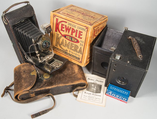Vintage Cameras: Vintage Cameras. Kewpie Roll Film Camera in original box with instructions by Sears & Roebuck and Co. Eastman Kodak 3-A Autographic Camera with leather case. Overall fair to good condition.