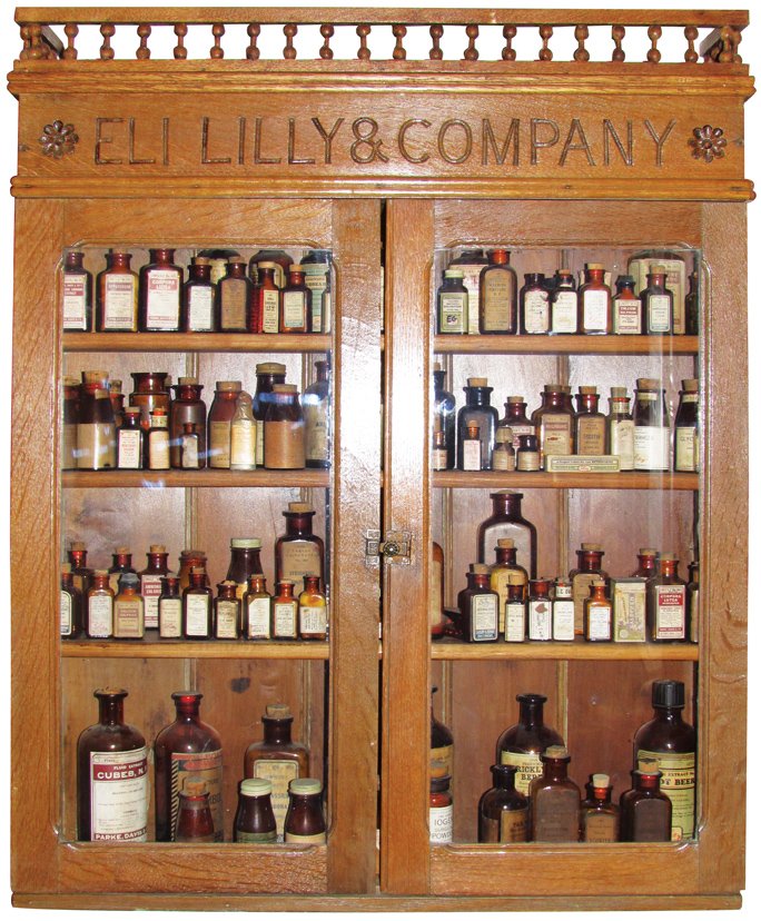 Eli Lilly & Company Oak Store Display Cabinet: Eli Lilly & Company Oak Store Display Cabinet. Comes with four shelves loaded with pharmacy product. Very good condition. 30 X 38 X 6 1/2 inches.