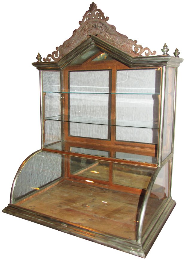 Cuban American Cigar Glass Showcase: Cuban American Cigar Co. Single Tower Curved Glass Showcase. F.X. Ganter Mfg. Baltimore. Nickel plated with cast iron marquis. Very good original condition. 35 1/4 X 49 X 24 3/4 inches.
