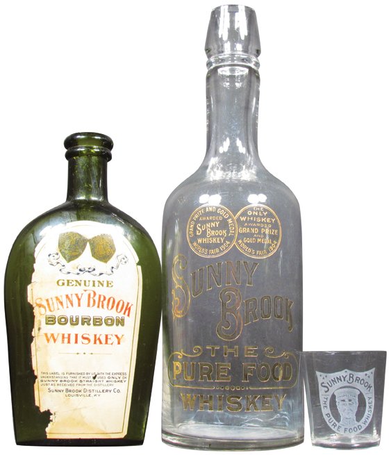 Collection of Sunnybrook Whiskey Saloon Items: Collection of Sunnybrook Whiskey Saloon Items. Etched glass decanter, Flask with original paper label and etched shot glass. No chips or cracks. Minor paper loss on label otherwise very good condition