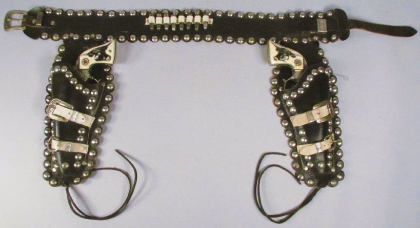 Pair of Hubley Texan Jr. Toy Cap Guns in Gun Rig: Pair of Hubley Texan Jr. Toy Cap Guns in Gun Rig. Black studded leather the white buckles. Guns have slight playwear.