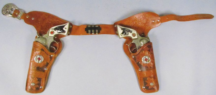 Pair of Hubley Texan Jr. Toy Cap Guns in Gun Rig: Pair of Hubley Texan Jr. Toy Cap Guns in Gun Rig. Hand tooled leather rig embossed Texas Ranger, floral motif. Guns show normal playwear.