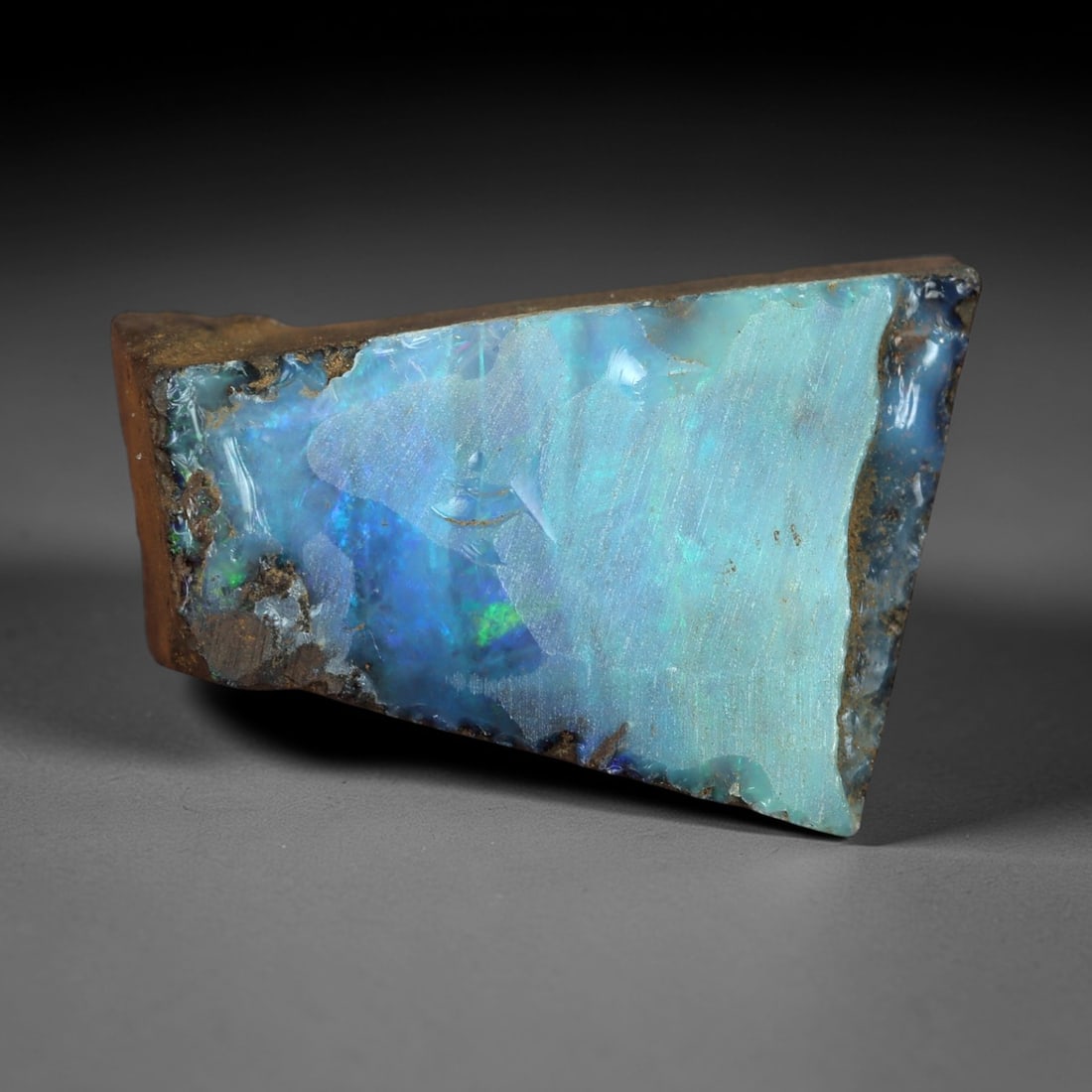 12.80 Carats Iridescent Sky Blue Winton Opal Rough - Natural Australian Specimen 18x11mm, 80XM: This exceptional rough opal from Winton, Australia, captivates with a vivid play of color, where intense flashes of sky blue and subtle turquoise swirl through a milky, translucent base. The natural, 
