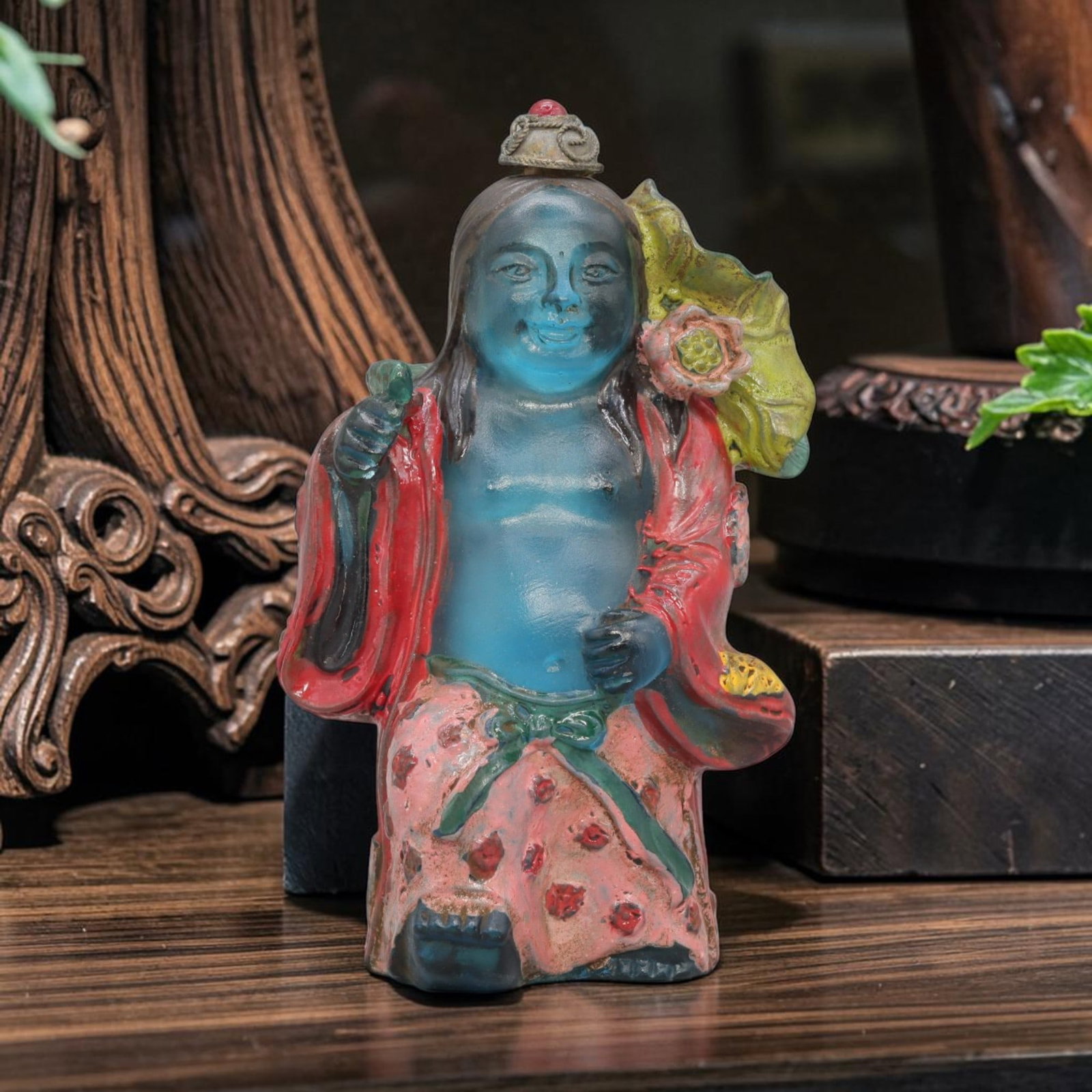 Vintage Chinese Enameled Liuli Snuff Bottle - Figure, 76YF: Crafted from translucent sky-blue liuli glass, this snuff bottle depicts a seated folk figure with a bare torso and smiling expression, draped in hand-painted enamel robes in red, pink, and green tone