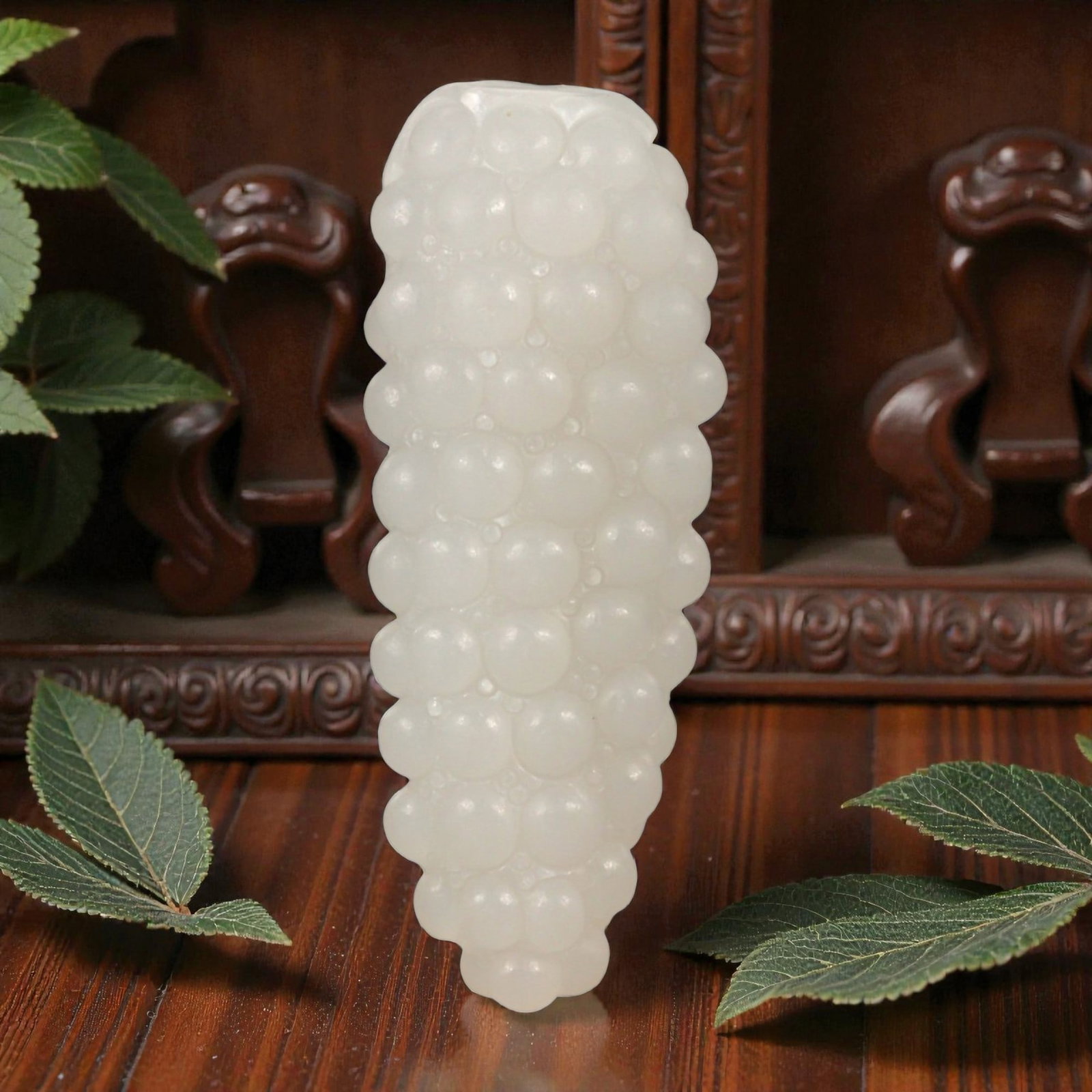 A Chinese Xinjiang Hetian Nephrite Jade Fruit Pendant, 20th Century, 5FC: Carved from pale white nephrite jade with a high degree of translucency and subtle natural clouding, the object is modeled in the form of a clustered fruit, likely grapes, rendered as a vertical arran