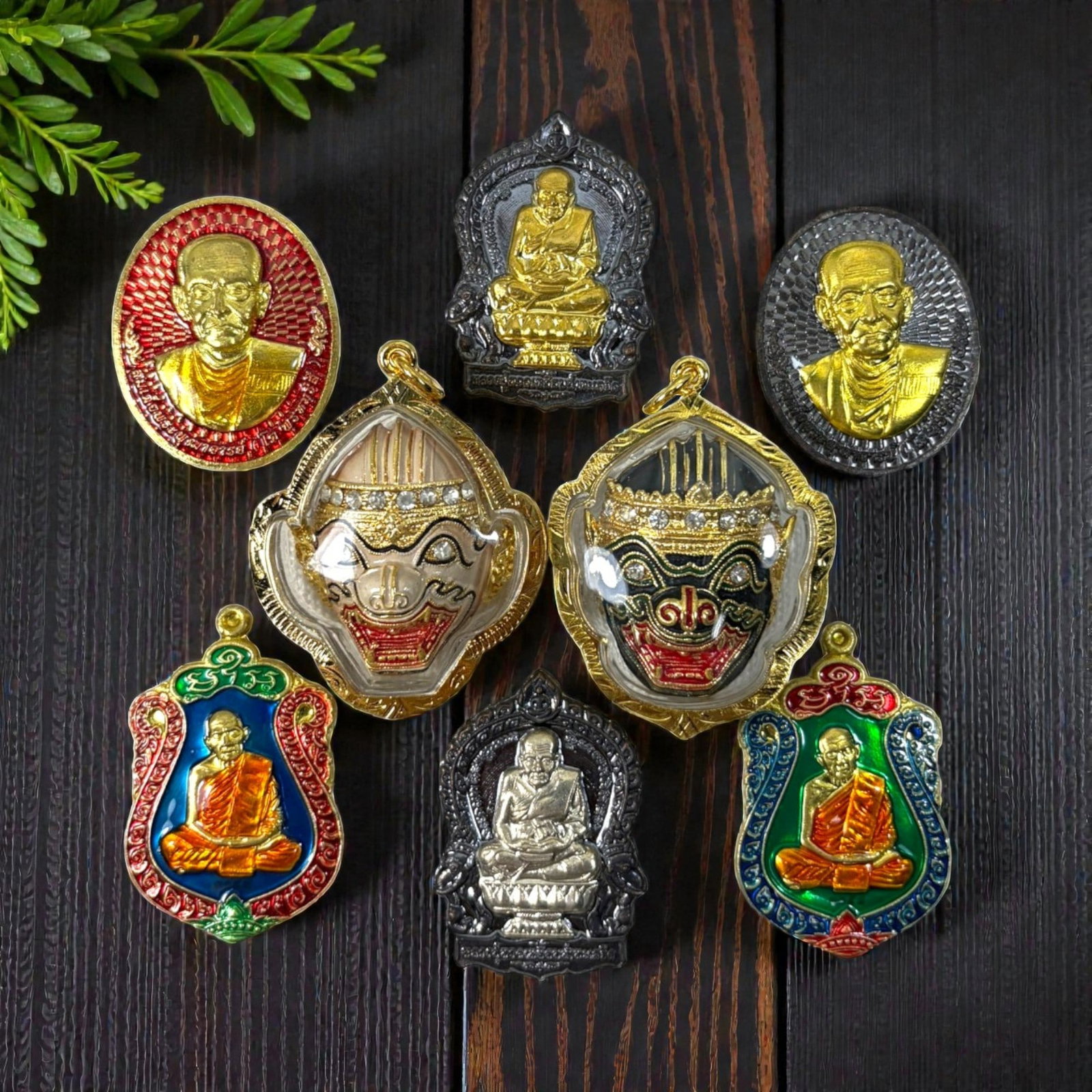 A Lot of 8 Vintage Gilt Thai Buddhist Amulets with Enamel Accents, 23AA: Comprising eight pendants ranging from 4 to 5 cm in height. The collection features a mix of revered monastic portraits, including both gilt and silver-toned reliefs, alongside two ornate enamel-faced