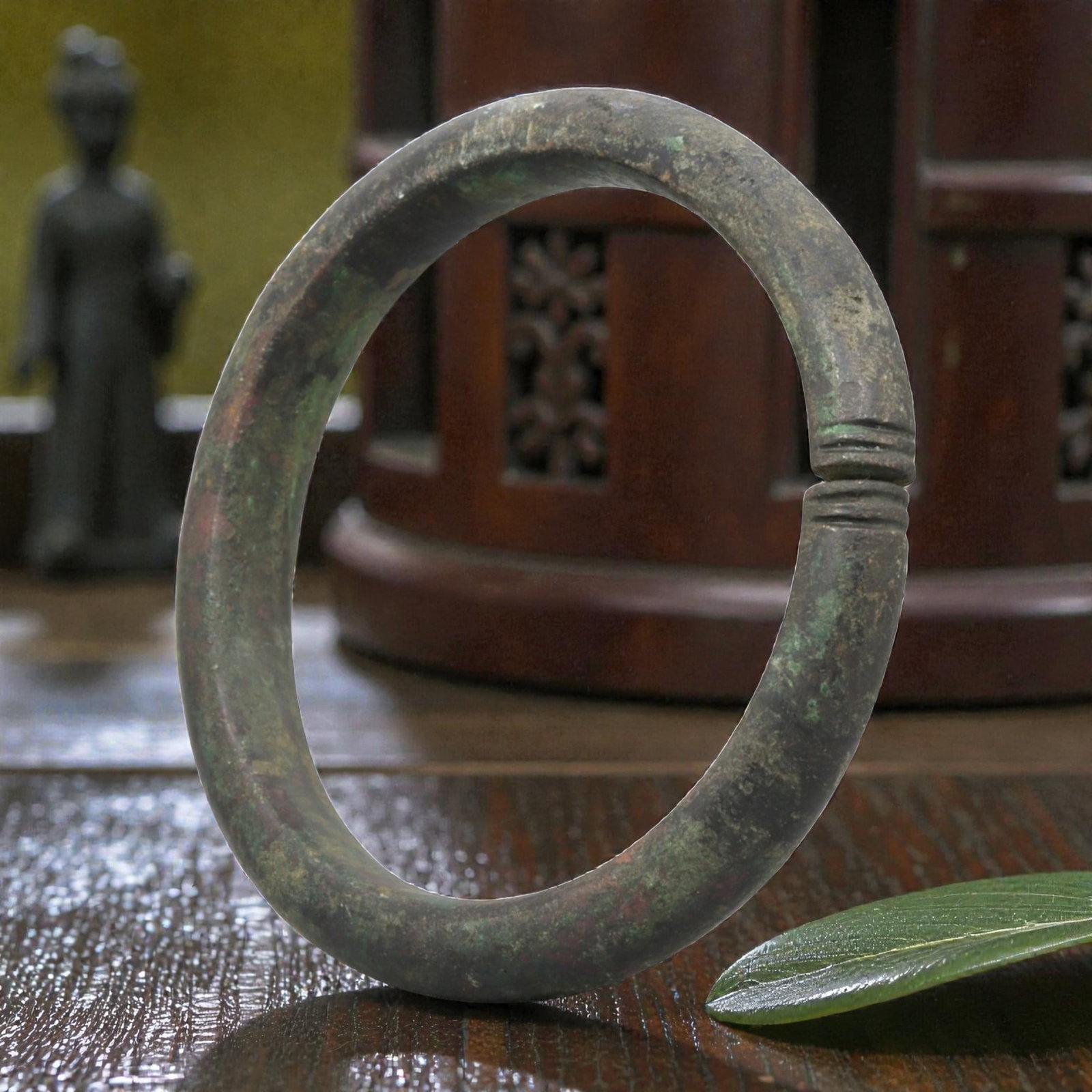 Ancient Roman Bronze Bracelet - Ribbed Split Terminal, 76BN: Crafted from bronze, this open bracelet features a rounded hoop form with neatly incised ribbed decoration at both split terminals, creating a subtle joining detail. The surface displays a rich, multi