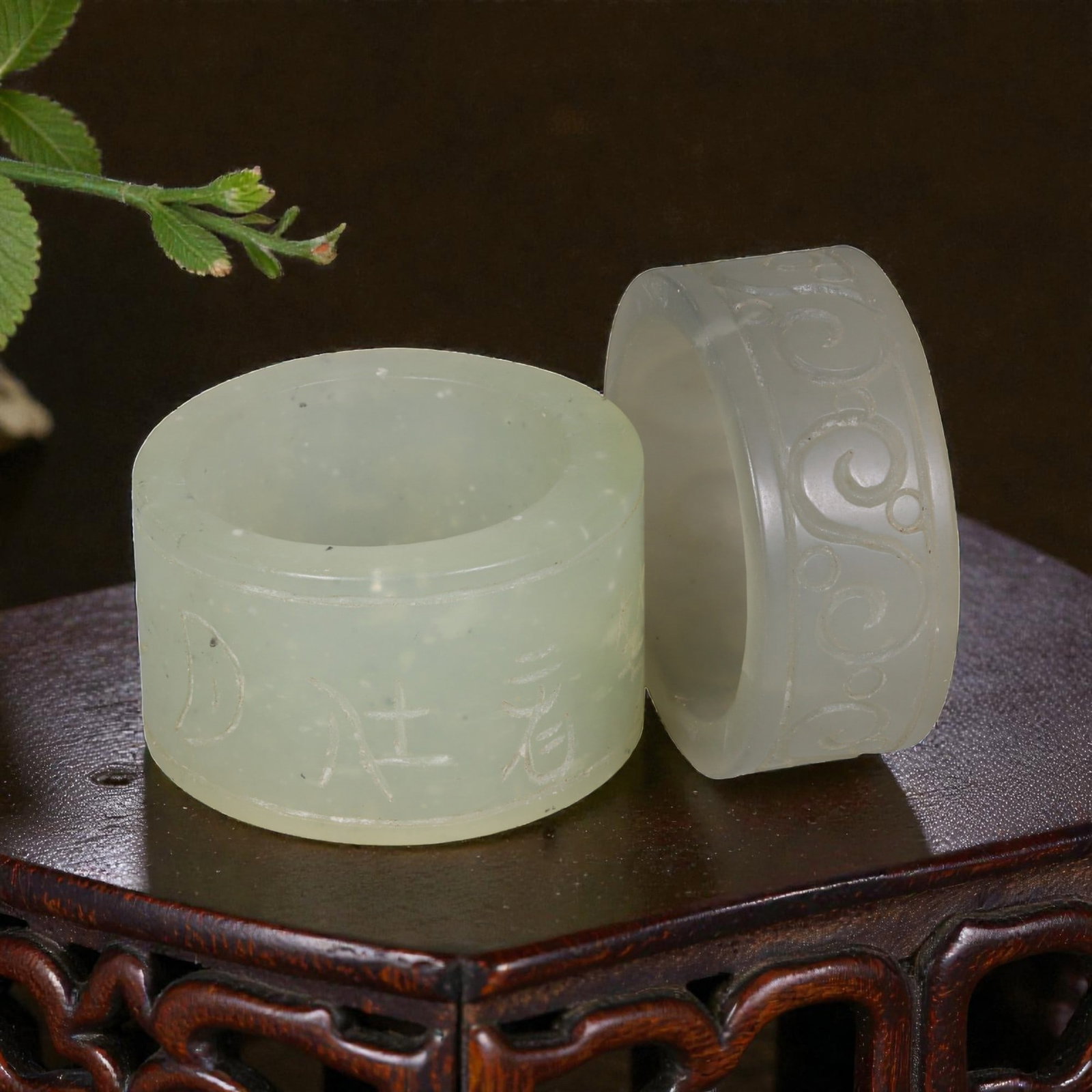 Lot of 2 Chinese Hetian Nephrite Jade Ring Pendants, 57AG: Carved from translucent pale green nephrite jade with natural inclusions, the two cylindrical pendants feature distinct incised decoration. The left example is light green with speckled inclusions, et