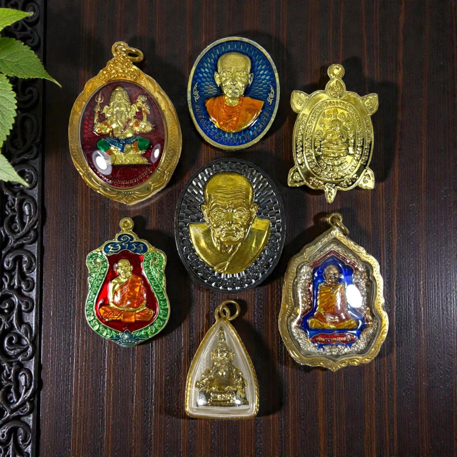 A Lot of 6 Vintage Gilt Thai Buddhist Amulets with Enamel Accents, 21AA: Comprising six pendants ranging from 3.5 to 4.5 cm in height. The collection features a diverse array of sacred imagery, including revered monastic portraits, a turtle-shaped prosperity amulet, and a 